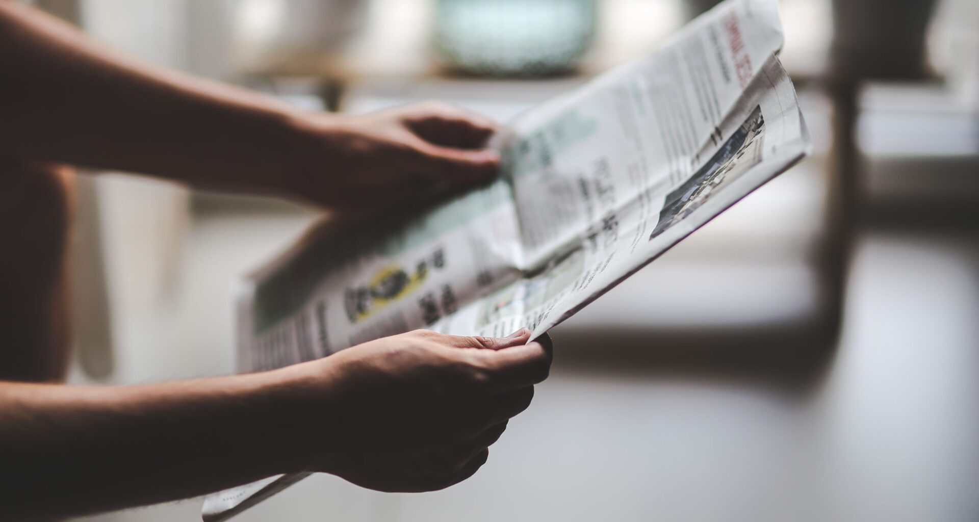 Eine Zeitung wird in den Händen gehalten