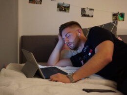 Mann im Bett mit Laptop